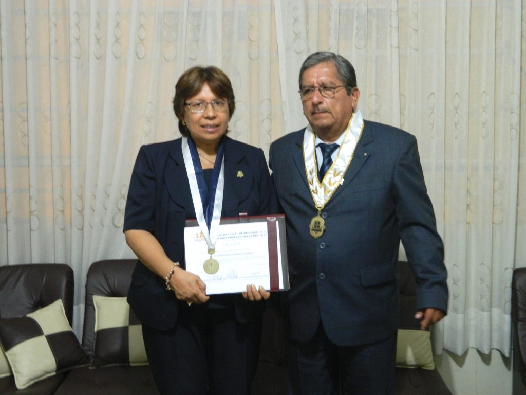 El presidente del CDCP, Dr. Julio Gutiérrez Pebe,  entrega la acreditación respectiva a la decana Gladys Martell.